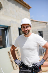 portrait of handsome construction worker on a house building industry construction site
