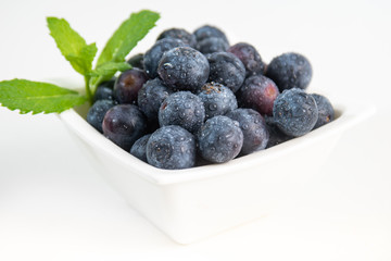 Blueberries with mint on white background