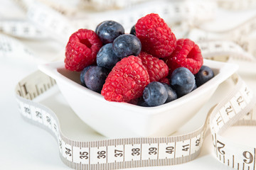 Berries with measure on white background