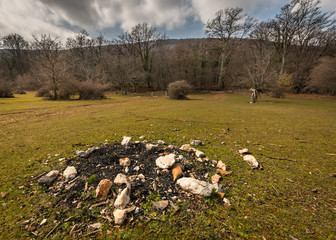 Abandoned fireplace on a meadow in Croatia on a partly cloudy day in spring
