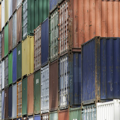 Untidy dirty multi-coloured shipping containers stacked high