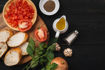 Preparing delicious Italian tomato bruschetta with chopped vegetables, herbs and oil