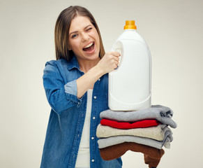 Smiling housekeeper holding stack of folded wool clothes with wh