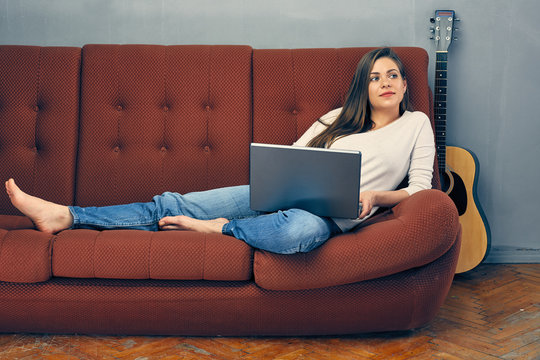 Woman relaxing with laptop at home.