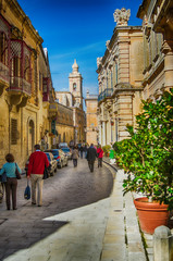 Valletta, Malta - February 18, 2013 Medieval old town typical narrow street with cars and people....