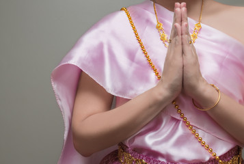 Beautiful Thai girl in traditional dress costume,press the hands together at the chest