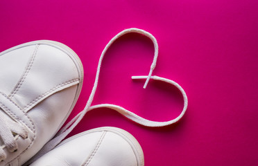 Original Valentine's Day love concept. white sneakers  on a pink background