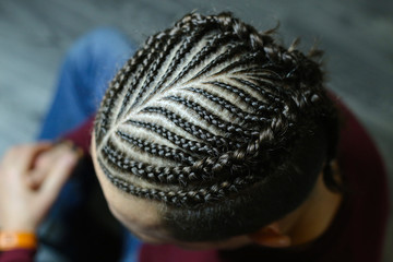 men's hairstyle from thin braids, creative waves of hair on the head of a man, head close-up, hair,...