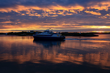 Fototapeta na wymiar Ship in sunset passing Bronnoysund in Northern Norway