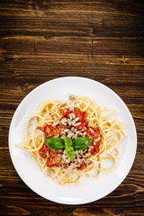 Pasta with meat and tomato sauce on wooden table