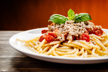 Pasta with meat and tomato sauce on wooden table