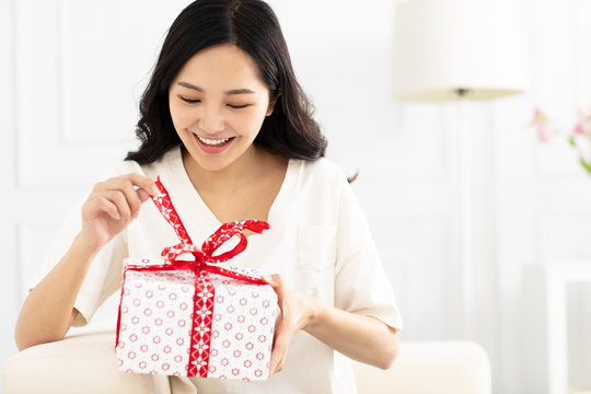 happy Young woman unpacking gift box