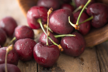 Cherry on wooden table with water drops macro background

