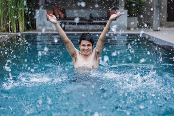 man in swimming pool and playing water splash