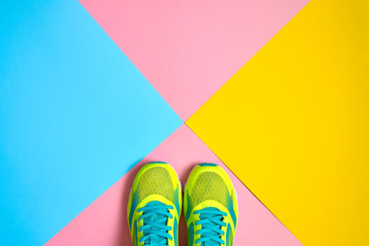 Pair Of Sport Shoes On Colorful Background. New Sneakers On Pink, Blue And Yellow Background, Copy Space. Overhead Shot Of Running Shoes. Top View, Flat Lay