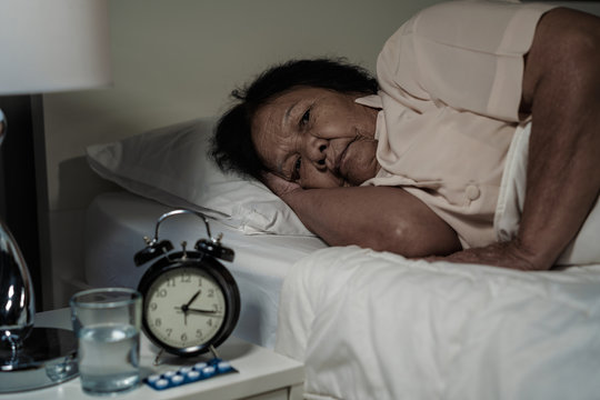 Old Woman Suffering From Insomnia Is Trying To Sleep In Bed