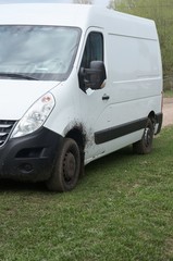 Dirty van parked on grass.