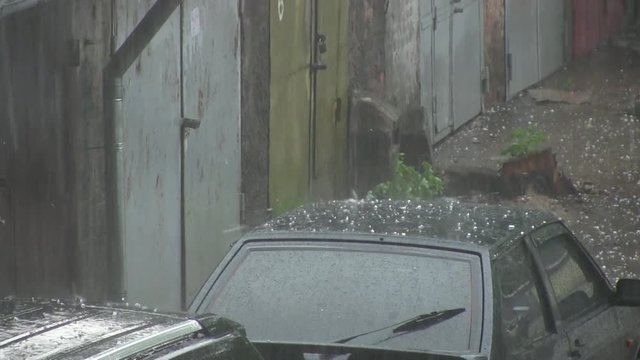 Large hail stones pelting car roof during storm