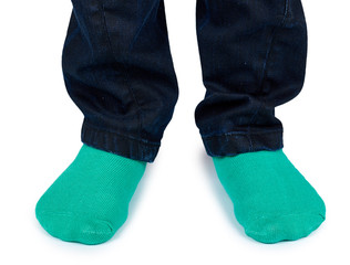 Kid legs in colored socks on leg isolated on white background