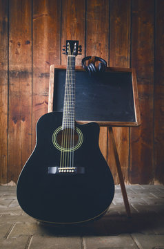 Acoustic guitar on a wooden texture with copy space for a text. Music and leisure concept. Guitar against wooden wall.