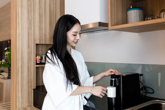 Beautiful asian woman making coffee for breakfast in the kitchen at home