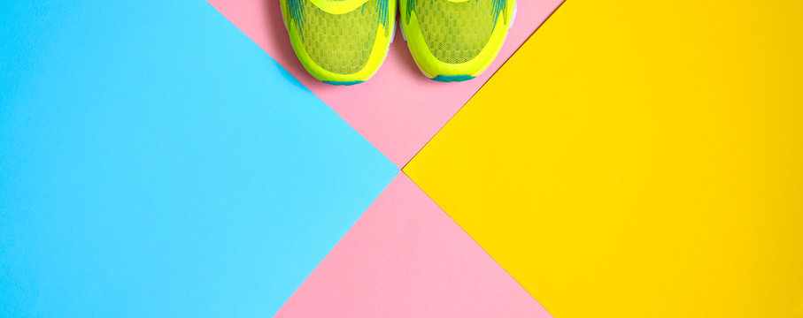 Pair Of Sport Shoes On Colorful Background. New Sneakers On Pink, Blue And Yellow Background, Copy Space. Overhead Shot Of Running Shoes. Top View, Flat Lay