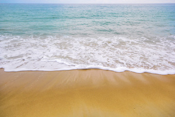 Soft wave of blue ocean on sandy beach. Background.