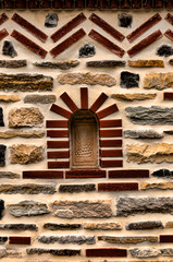 A colorful stagger of rocks and bricks cemented as a unique design for a wall.