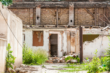 Interior remains of hurricane or earthquake disaster damage on ruined old house in the city with collapsed walls, roof and bricks with selective focus