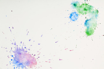colored watercolor blots on paper on white background