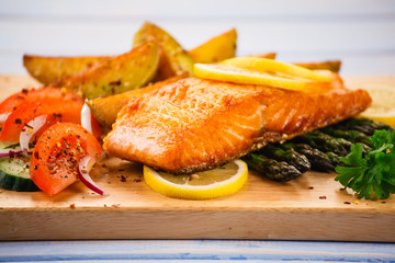 Fresh raw salmon fish served on black stone on wooden table