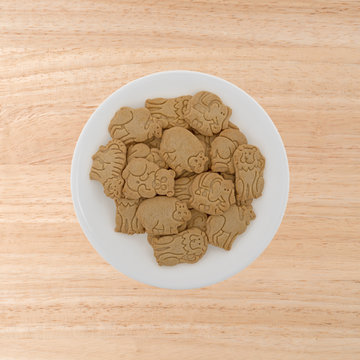 Plate Of Vanilla Animal Cookies On A Wood Table.