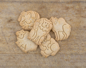 Group of vanilla animal cookies on an old wood cutting board.