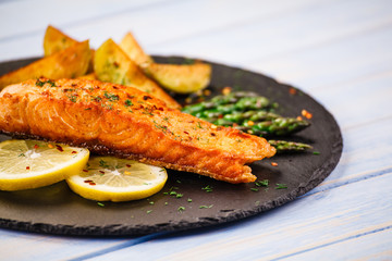 Grilled salmon with vegetables on wooden table