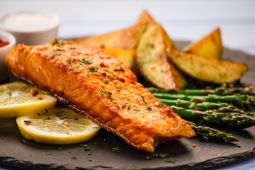 Grilled salmon with vegetables on wooden table