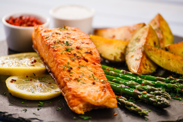 Grilled salmon with vegetables on wooden table