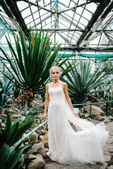 Woman stand in the Botanical green garden full of greenery. Wedding ceremony. Portrait attractive...