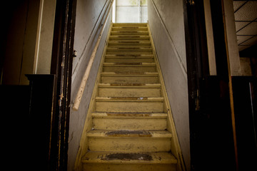 Old dirty damaged abandoned wooden stairs to the garret. Entrance to the attic.