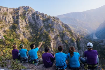 Foto op Plexiglas Group of mountaineers sitting on peak © qunica.com