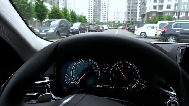 View of dashboard while driving car in city.
