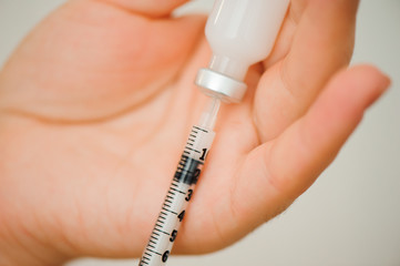 Girl picking up insulin in a syringe close-up. Diabetes.