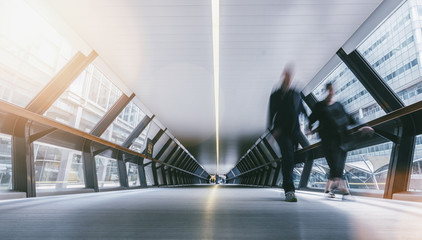 Silhouettes of blurred people in a futuristic tunnel