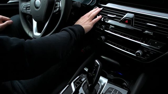 Man pushes start engine button in the car.