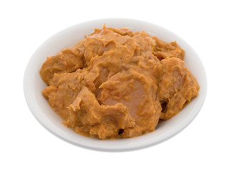 Bowl of curry flavored tuna isolated on a white background.