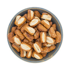 Top view of bite size sourdough pretzels in an old stoneware bowl isolated on a white background.