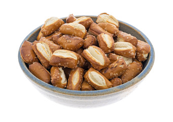 Bite size sourdough pretzels in an old bowl isolated on a white background.