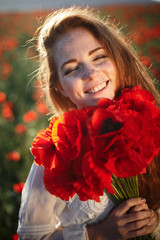 Young beautiful woman smiling in a poppy field