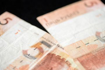 Two Belarusian banknotes in five rubles on a dark background close up