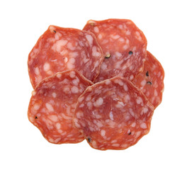 Slices of uncured soppressata dry salami in a group top view isolated on a white background.
