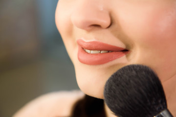 Beauty and health clean Skin of young female Model. Woman applying Powder Foundation with Brush.